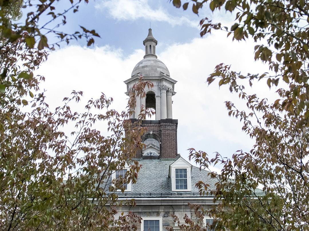 Old Main bell tower framed by leaves